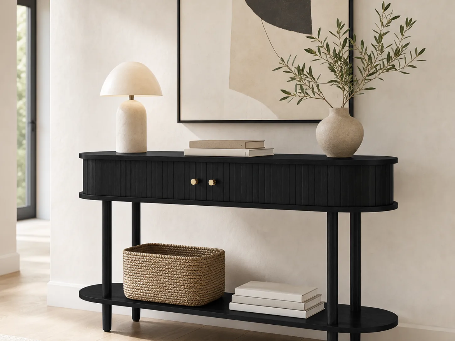 A black fluted console table from our range, styled with a lamp, a vase and a basket
